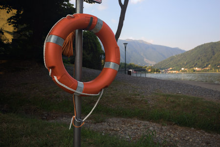 Life buoy hanging on a pole next to a lakeshore
