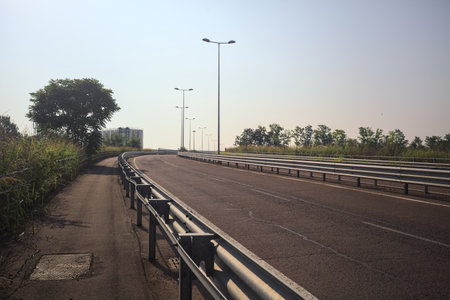 Highway passing through an industrial complex in the Italian countryside on a summer day