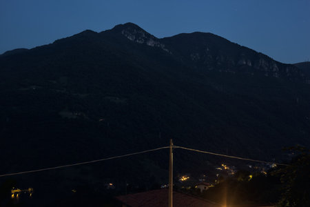 Village in the mountains at night with ridges in the distanceの写真素材