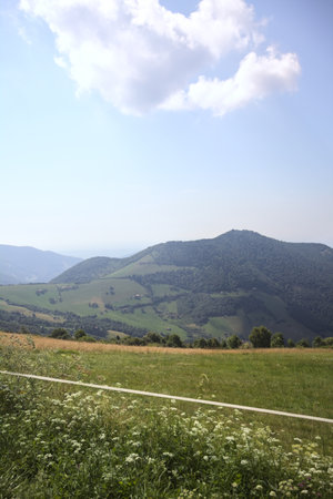 Field on a mountain slope with ridges on the horizon on a sunny day