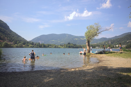 Monasterolo al Castello, Italy - August 2024 - People swimming and standing by the lakeshoreのeditorial素材