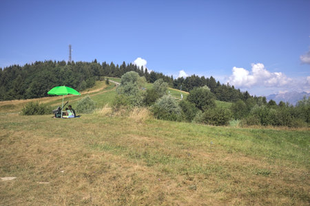 Grone, Italy -- August 2024 - People sunbathing and relaxing on a grassy plateau of a mountainのeditorial素材