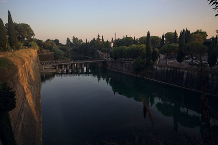 Moat of a fortification with a bridge over it at sunsetの写真素材