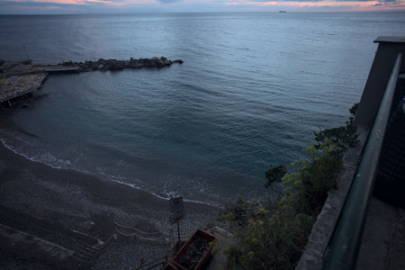 Sea stretching to the horizon with breakwaters on a cloudy nightfall