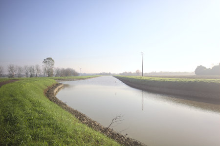 Bike lane next to a creek in the Italian countryside on a sunny dayの写真素材