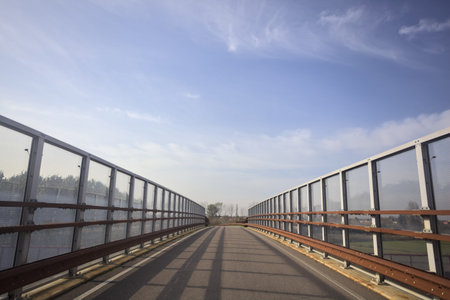 Paved bridge bordered by a barrier on a cloudy day