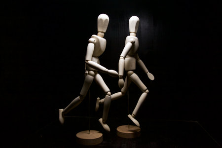 Mannequins in the act of running on a black background seen up close