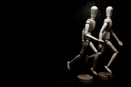 Mannequins in the act of running on a black background seen up closeの写真素材
