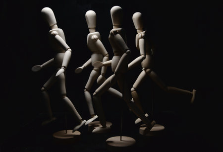 Mannequins in the act of running on a black background seen up closeの写真素材