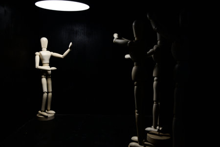 Mannequins applauding another one under a spotlight on a black backgroundの写真素材