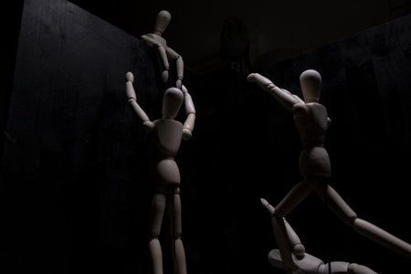 Mannequins reaching out to one above them with open arms on a black backgroundの写真素材