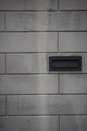 Opening of a letterbox in a stone wall seen up closeの写真素材