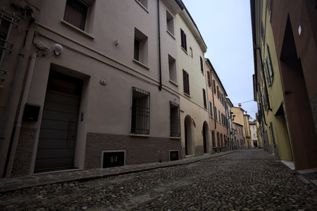 Cobbled alley that narrows at its end in an Italian town on a cloudy day