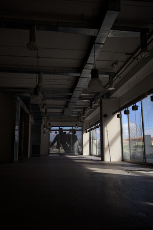 Empty shop without any furniture but lamps in an abandoned mall on a sunny day