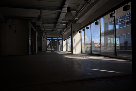 Empty shop without any furniture but lamps in an abandoned mall on a sunny day