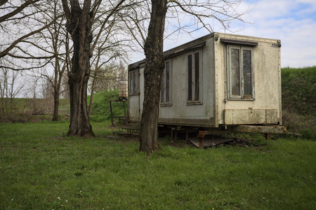 Abandoned building on a lawn with bare trees in the countrysideの写真素材