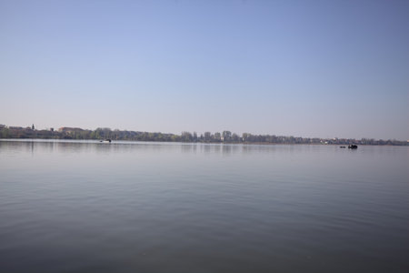 Boats floating on a lake in the countryside on a sunny day seen from afarの写真素材