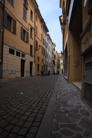 Narrow street with tall buildings in an Italian town
