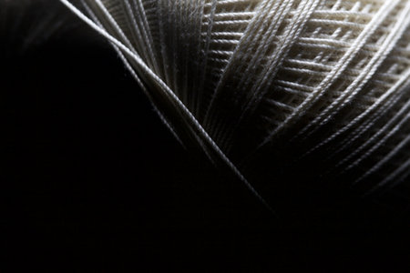 Sewing thread on a black background seen up closeの写真素材