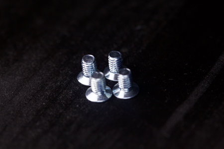 Screws on black background seen up close