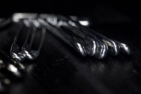 Safety pins on a black background seen up closeの写真素材