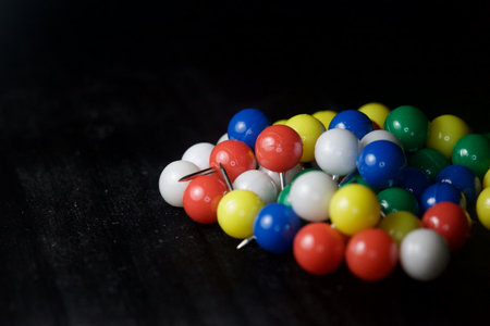 Colored pushpins on a black background seen up closeの写真素材