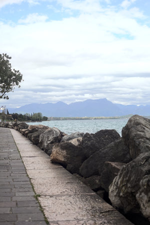 Promenade bordered by a breakwater on a cloudy day by the lakeshoreの写真素材