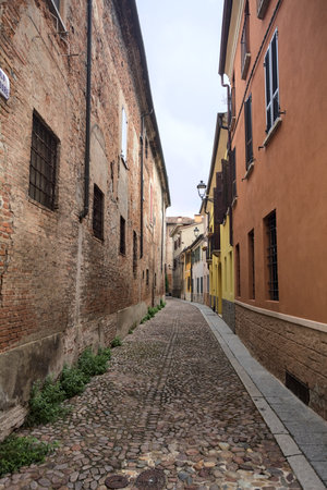 Narrow cobbled alley partly in the shade on a cloudy day in an Italian townの写真素材