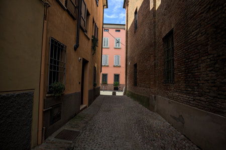 Cobbled and narrow alley in the shade on a sunny day in an Italian townの写真素材
