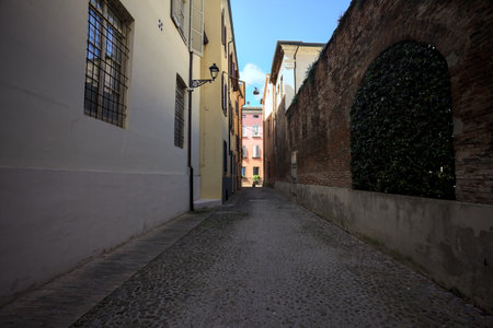 Cobbled and narrow alley in the shade on a sunny day in an Italian townの写真素材