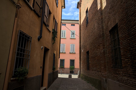 Cobbled and narrow alley in the shade on a sunny day in an Italian town