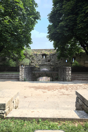 Paved small square in a park next to a boundary wall of a castle on a sunny dayの写真素材