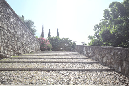 Staircase leaning on the inner wall of a castle on a sunny dayの写真素材