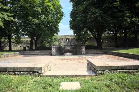 Paved small square in a park next to a boundary wall of a castle on a sunny dayの写真素材