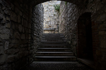 Stone staircase in the shade passing under an archwayの写真素材