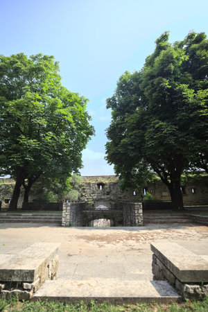 Paved small square in a park next to a boundary wall of a castle on a sunny dayの写真素材