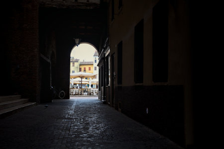 Covered alley passing through a palace bordered by windows in an Italian townの写真素材