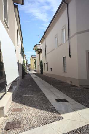 Corner of a building at the beginning of a cobbled alley on a sunny day in an Italian townの写真素材
