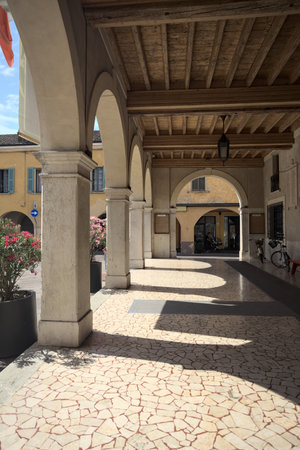 Porch of a historical building in a square of an Italian town on a sunny dayの写真素材