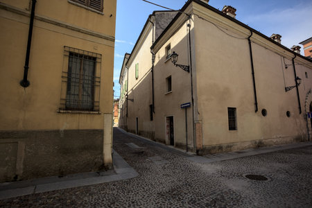 Crossroads between two cobbled streets and the corner of a building seen from the opposite side of the streetの写真素材