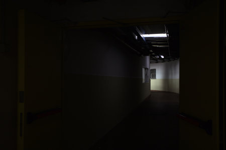 Dimly lit corridor with tubes on its ceiling