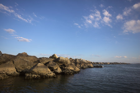 Breakwater near a beach by the seaside at sunset on a clear and sunny day