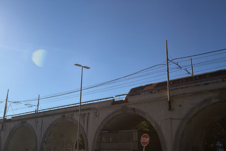 Train passing on a bridge with a clear sky as background