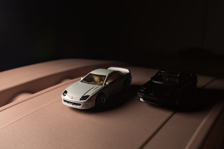 Mantua, Italy - 9TH DECEMBER 2025 - Replicas of a white Mitsubishi 3000GT and a black Toyota MR2 on a toy pretending to have a race on a mountain passのeditorial素材