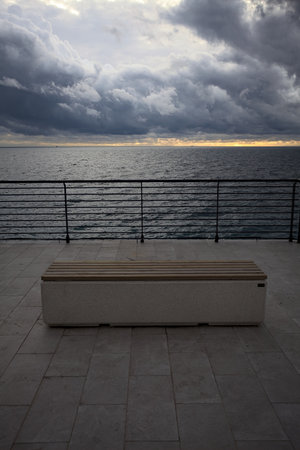 Bench on a balcony on the top of a cliff by the sea at twilight