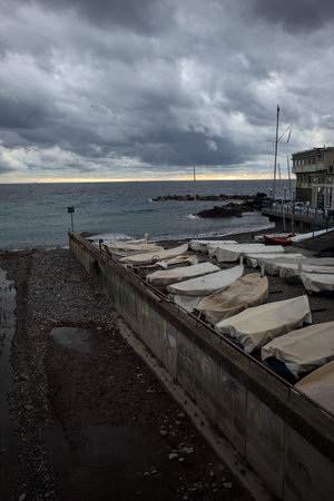 Channel on a beach with two boathouses on each side, on a cloudy day at twilight, seen from above a bridgeの写真素材