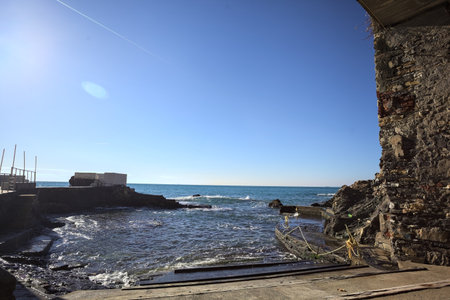 Narrow cove without people bordered by rocks and a panoramic point with a bridge above it on a sunny...