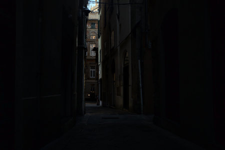 Narrow alley in the shade on a cloudy dayの写真素材