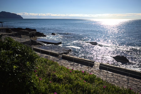 Descending stone path in a cliff to the sea seen from above on a sunny day