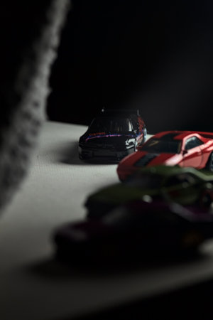 Mantua, Italy - 3RD JANUARY 2025 - Hot Wheels replicas of various Nissan Skyline models, two R30, a GT-R R32 and a GT-R R33, on a white board, next to a gray piece of fabric, pretending to have a race on a mountain road by the edge of a cliffのeditorial素材